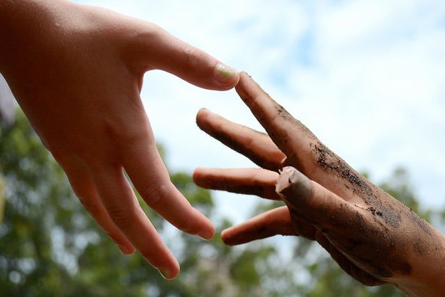 One hand reaching for another hand